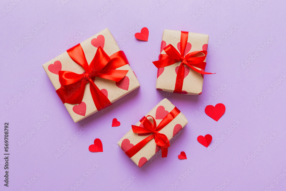 Top view photo of valentine day decorations gift box with red ribbon bow on colored background. Holiday gift boxes with top view Top view photo of valentine day decorations gift box with red ribbon bow on colored background. Holiday gift boxes with top view