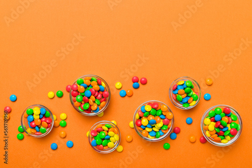 different colored round candy in bowl and jars. Top view of large variety sweets and candies with copy space