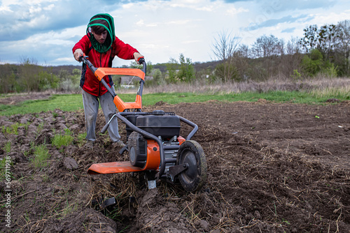 Work on the field of a home farm. Plowing the garden with a cultivator or tiller. Unplowed field after furrow processed by a motor cultivator photo