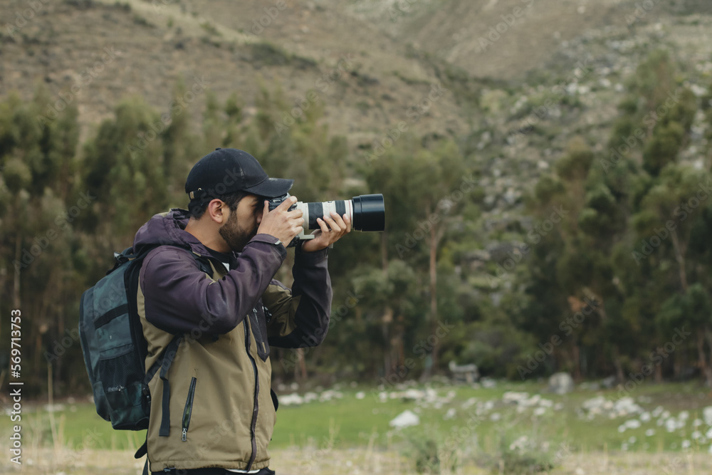 Photographer taking pictures with his camera in a green valley of the Andes mountain range in Peru. Concept professions, people and vacations. Photographer taking pictures with his camera in a green valley of the Andes mountain range in Peru. Concept professions, people and vacations.