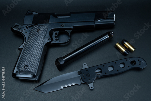 Weapon.  Model M1911 pistol and folding tactical knife.