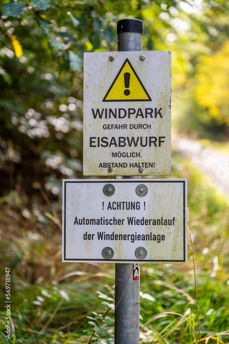 Close-up german yellow warning sign attention ice can fall down from the wind turbine