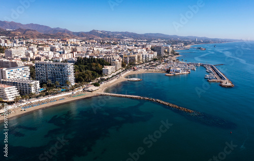 Aerial view of resort town of Marbella by Mediterranean coast in foothills of Sierra Blanca mountain range on sunny fall day  Spain