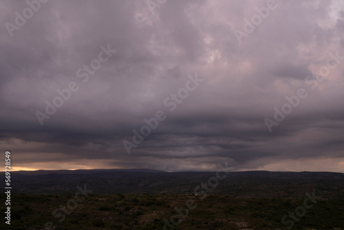 Dramatic cloudscape. Panorama view of the hills and field under a cloudy sky, at dusk.