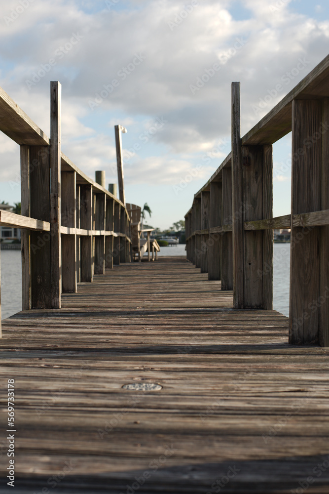 Wooden pier dock looking out to sunny blue cloudy sky