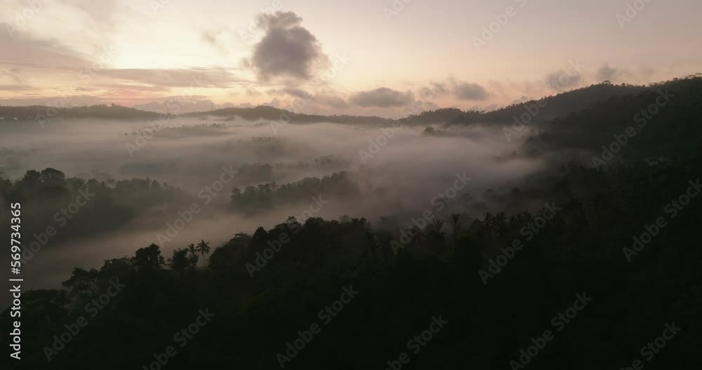 Aerial Tranquil View Of Clouds In Mountains, Drone Flying Forward Over Forest At Sunrise - Bali, Indonesia Aerial Tranquil View Of Clouds In Mountains, Drone Flying Forward Over Forest At Sunrise - Bali, Indonesia