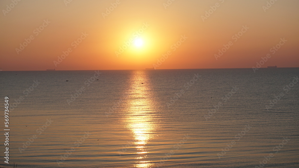 Naklejka premium Bright orange sunrise over the sea clear sky view