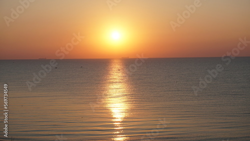 Bright orange sunrise over the sea clear sky view © Yamaikina