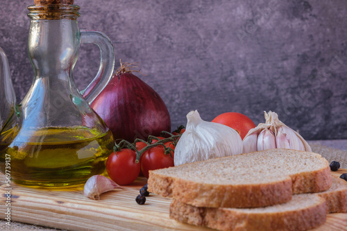 Country lunch based on bread, garlic, vine tomatoes, red onion, peppercorns and virgin olive oil photo