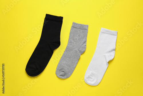 Different socks on yellow background, flat lay