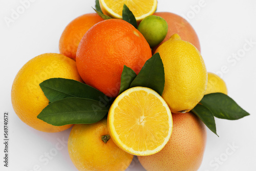 Different citrus fruits and leaves on white background  closeup
