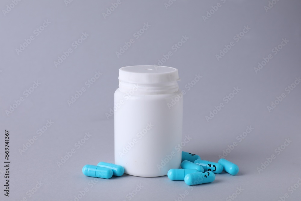 Antidepressants with happy emoticons and medical jar on light grey background Antidepressants with happy emoticons and medical jar on light grey background