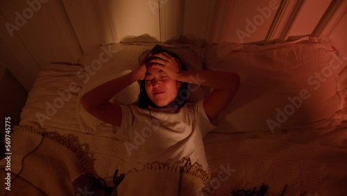 Depressed Asian woman cannot sleep insomnia suffering from insomnia lying in bed