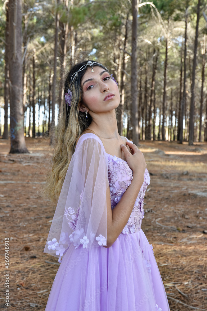 Close up portrait of beautiful young blonde model wearing a purple princess fantasy ball gown with flower crown diadem.
Pine forest location background with golden lighting. Close up portrait of beautiful young blonde model wearing a purple princess fantasy ball gown with flower crown diadem.
Pine forest location background with golden lighting.
