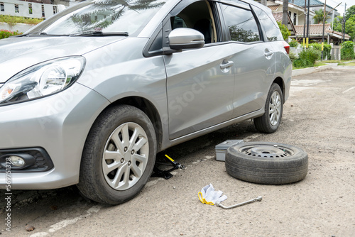 Car with jack and wrench for tire replacement