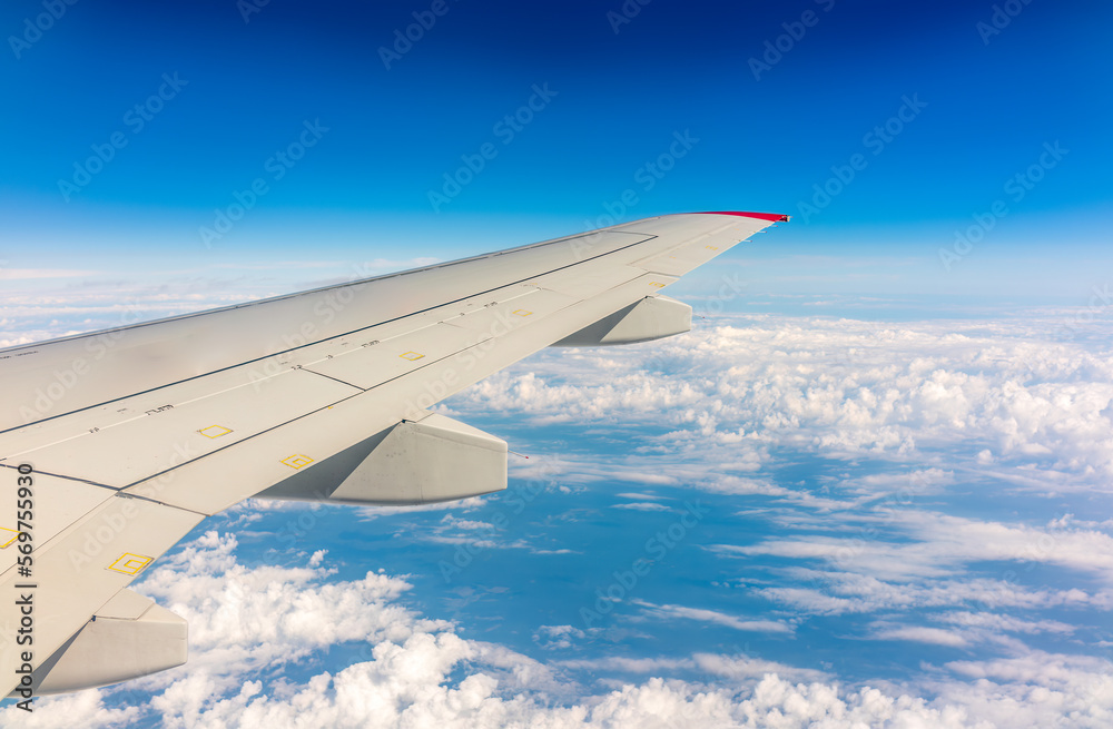 View from the airplane window at a beautiful cloudy sky and the airplane wing View from the airplane window at a beautiful cloudy sky and the airplane wing