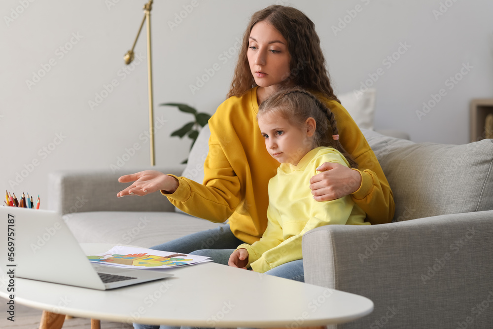 Little girl and her mother video chatting with psychologist on laptop at home Little girl and her mother video chatting with psychologist on laptop at home