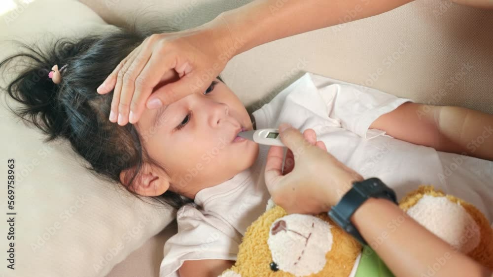 Sick kid. Mother parent checking temperature of her sick daughter with