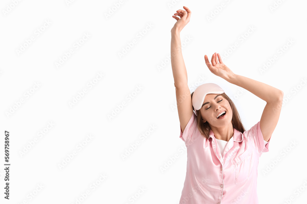 Beautiful woman in pajamas stretching on light background Beautiful woman in pajamas stretching on light background