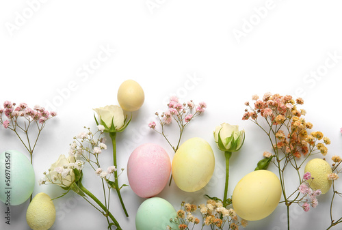 Photography Composition with painted Easter eggs and flowers on white background, closeup