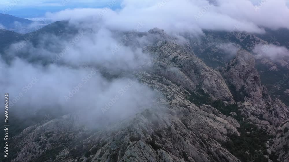 Aerial view of low clouds on top of rocky mountains, blue hour in Sardinia, Italy Aerial view of low clouds on top of rocky mountains, blue hour in Sardinia, Italy