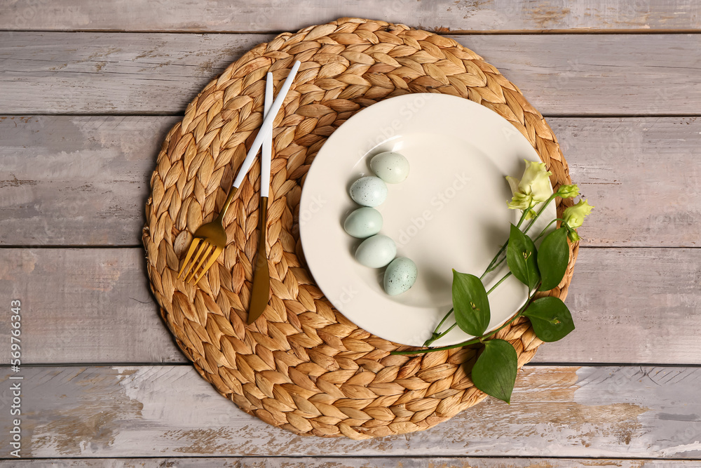 Table serving with Easter eggs and eustoma flowers on grey wooden background Table serving with Easter eggs and eustoma flowers on grey wooden background