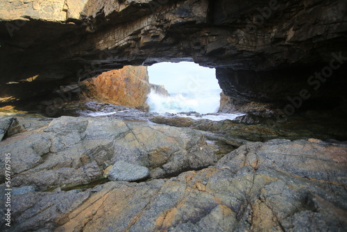 The bright light from the sea cave to the stone beach inside the cave in Cape D’Aguilar Peninsula, Hong Kong
