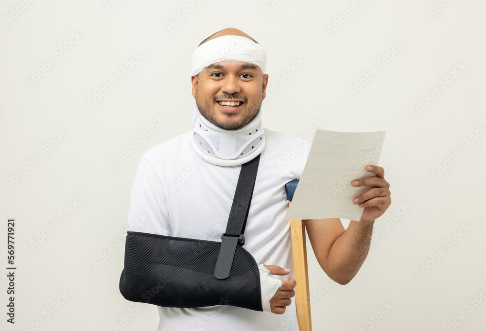 Asian man broken arm and leg holding bill payment. Man put on plaster cast splint with walking sticks crutches. Patient wearing sling support arm with neck collar. life insurance and accident Asian man broken arm and leg holding bill payment. Man put on plaster cast splint with walking sticks crutches. Patient wearing sling support arm with neck collar. life insurance and accident