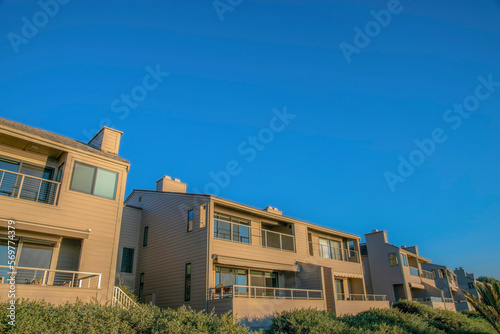 Homes with balconies overlooking beach at sunny Del Mar Southern Califronia. Facade of seaside houses against clear blue sky on a quiet and beautiful sunny day.