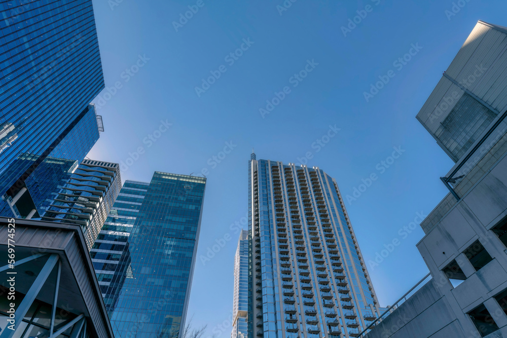 Looking up at modern residential buildings exterior towering against blue sky. Austin Texas skyline viewed from the street with facade of apartments, condominiums and offices.