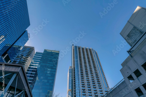 Looking up at modern residential buildings exterior towering against blue sky. Austin Texas skyline viewed from the street with facade of apartments  condominiums and offices.