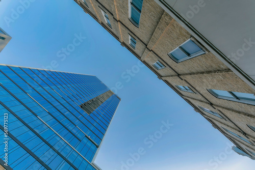 Exterior view of glass building and apartments against blue sky in Austin Texas. Looking up at city houses and flats with modern architecture design at the facade.