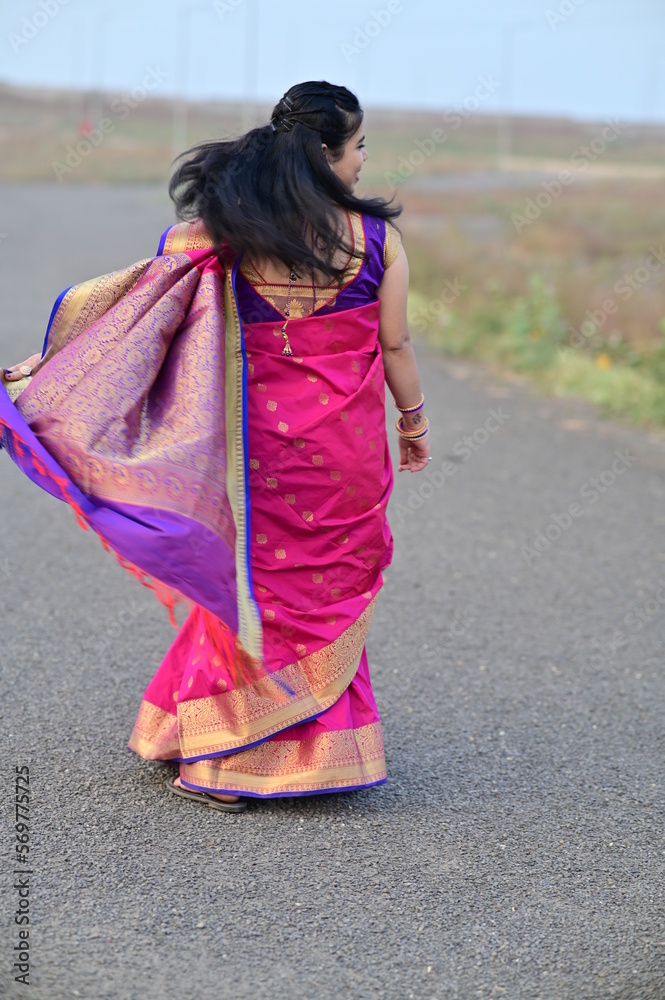 Walking indian bride in saree. Elegance look. Indian Bride in the Saree. Back side of wedding saree. Indian traditional dress. Maharashtra Bride. Maharashtra saree. woman walking on the street Walking indian bride in saree. Elegance look. Indian Bride in the Saree. Back side of wedding saree. Indian traditional dress. Maharashtra Bride. Maharashtra saree. woman walking on the street