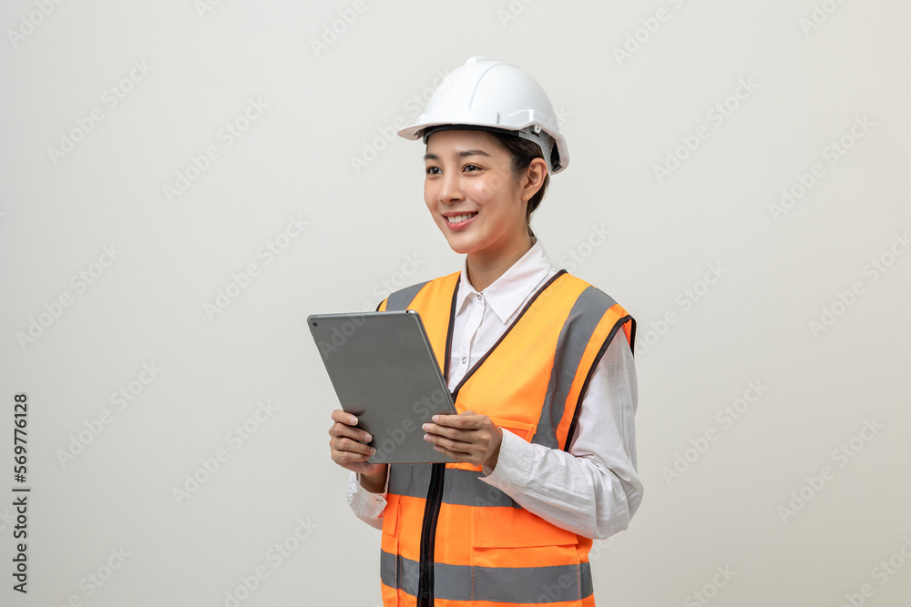 Asian engineer worker woman or architect with white safety helmet standing on isolated white background. Mechanic service factory Professional job occupation in uniform working with tablet Asian engineer worker woman or architect with white safety helmet standing on isolated white background. Mechanic service factory Professional job occupation in uniform working with tablet