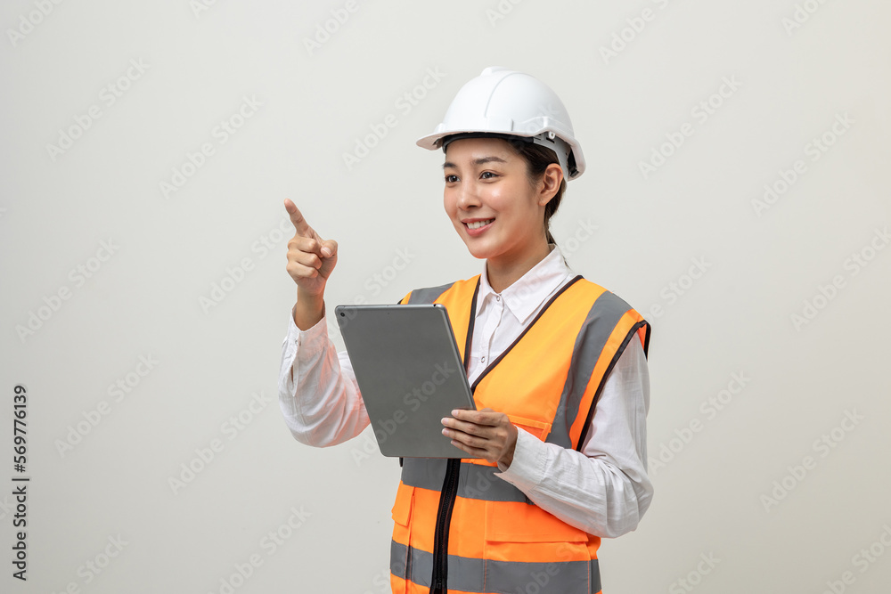 Asian engineer worker woman or architect with white safety helmet standing on isolated white background. Mechanic service factory Professional job occupation in uniform working with tablet Asian engineer worker woman or architect with white safety helmet standing on isolated white background. Mechanic service factory Professional job occupation in uniform working with tablet