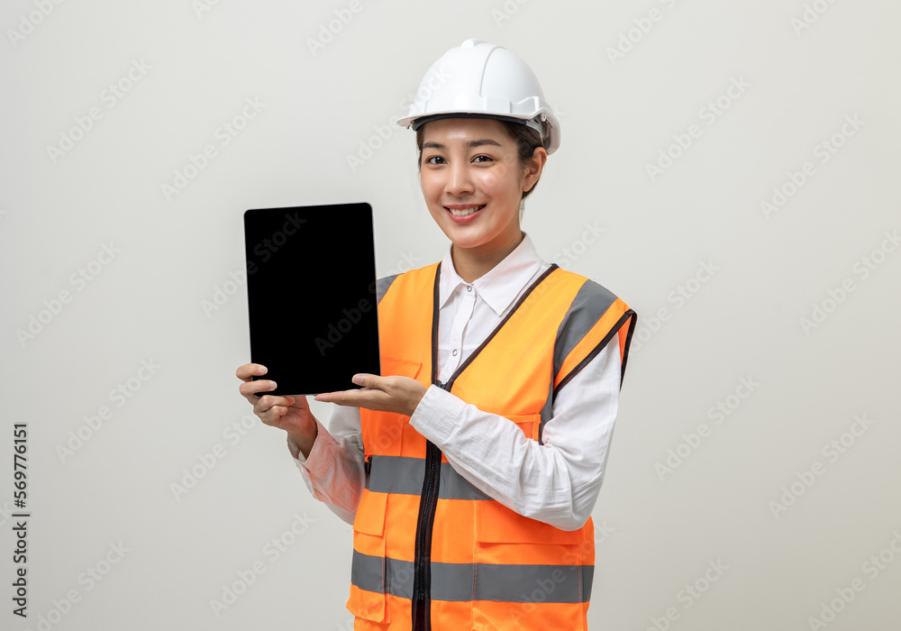 Asian engineer worker woman or architect with white safety helmet standing on isolated white background. Mechanic service factory Professional job occupation in uniform working with tablet Asian engineer worker woman or architect with white safety helmet standing on isolated white background. Mechanic service factory Professional job occupation in uniform working with tablet