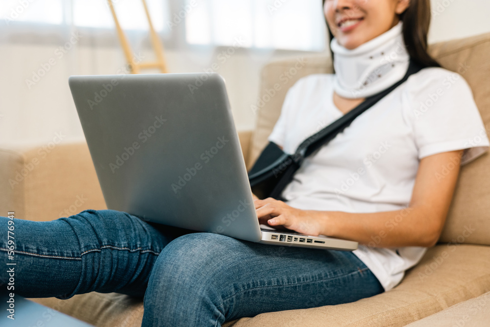 Happy woman recovery from accident fracture broken bone injury with leg splints in cast neck splints collar arm splints sling support arm with tablet. Social security and health insurance concept.