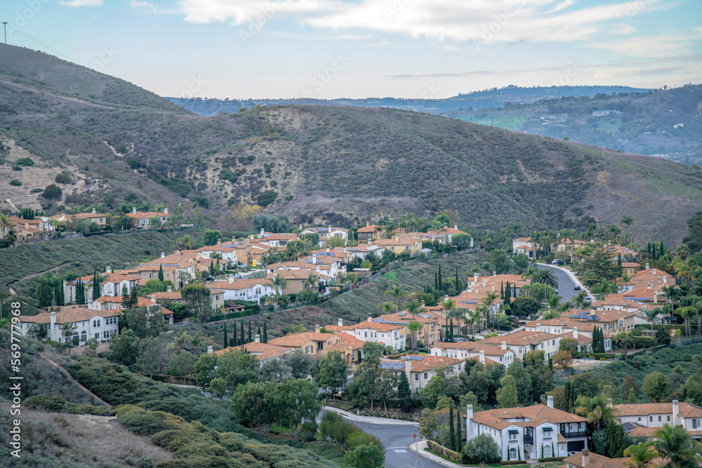 View of a residential area on a slope from a hiking trail at San Clemente, California. Subdivision on a mountain with a view of sky at the background.