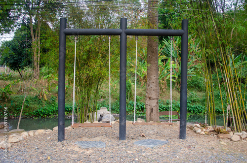 The swing is located in the garden in the middle of nature.