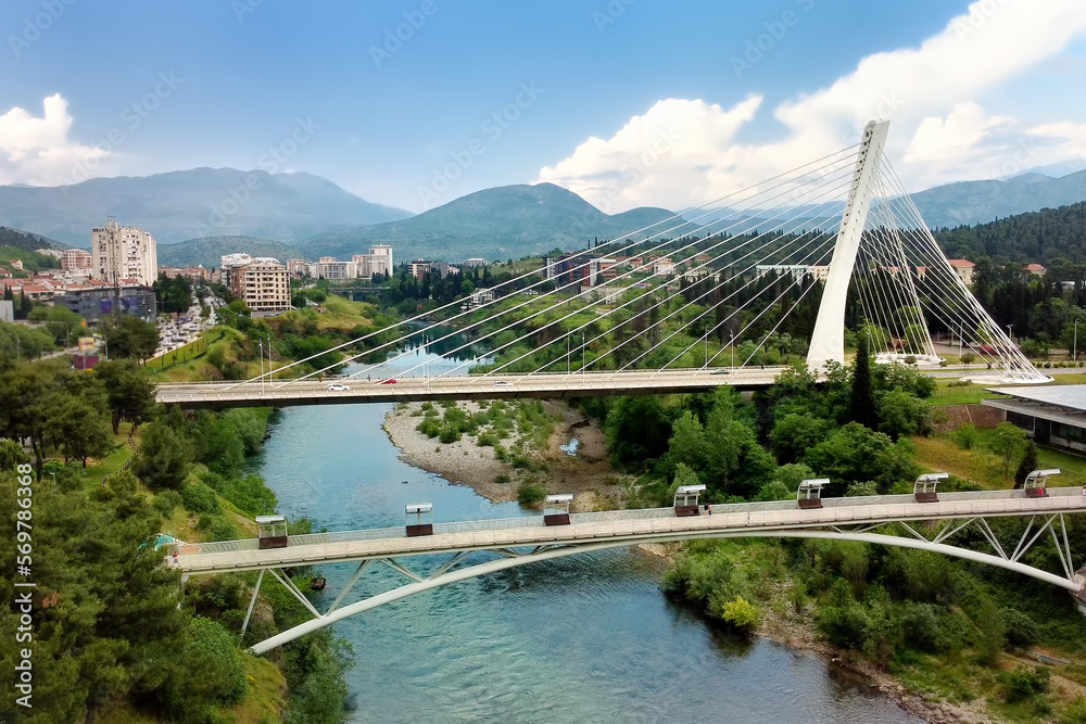 Aerial drone view of cable stayed Millennium bridge, footpath bridge and Moraca river in Podgorica, Montenegro.