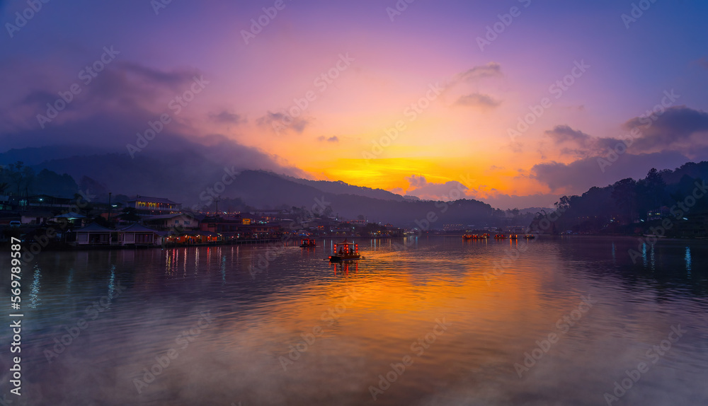 Tourists take a boat with mist fog over lake in morning at Ban Rak Thai village in Mae Hong Son province, Thailand. Tourists take a boat with mist fog over lake in morning at Ban Rak Thai village in Mae Hong Son province, Thailand.