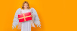 Angel child hold gift present. Cute angel child, studio portrait. Banner header, copy space. Angel kid with angels wings, isolated background.