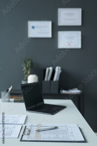 Vertical image of workplace of manager with resumes of candidates on table during job interview