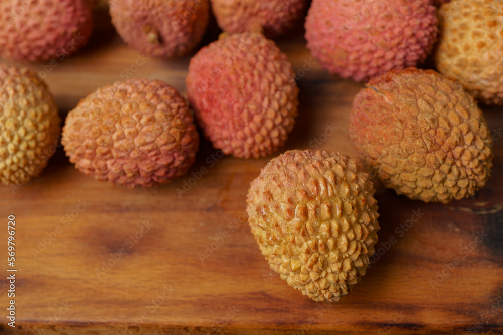 group of fresh lychees on a wooden board group of fresh lychees on a wooden board