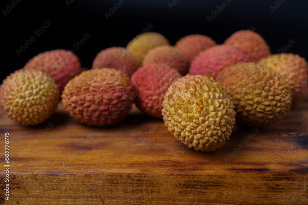 group of fresh lychees on a wooden board group of fresh lychees on a wooden board
