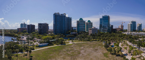 Panorama of beautiful Miami Florida city skyline on a bright sunny day. Modern buildings, partial view of ocean, and wide green lawn can be seen in this scenic landscape. © Jason