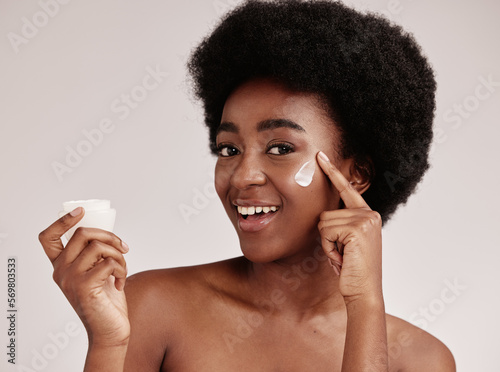 Skincare, product and portrait of black woman with cream on face, smile and advertising skin care promotion. Dermatology, cosmetics and facial for happy model with jar isolated on studio background.