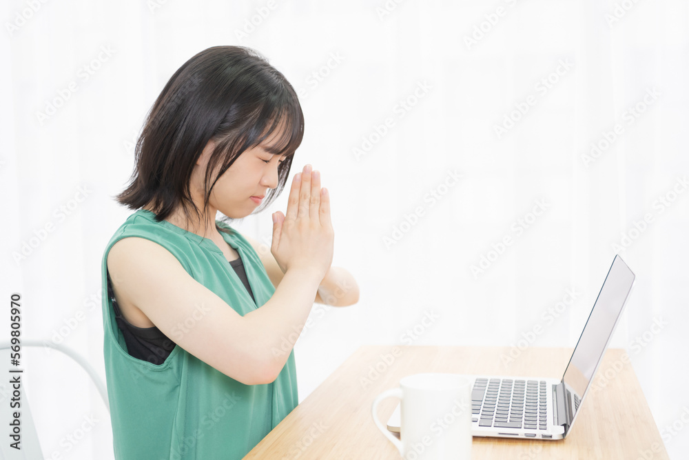 © garage38 - PCの前で手を合わせて祈っている若い女性 © garage38 - PCの前で手を合わせて祈っている若い女性