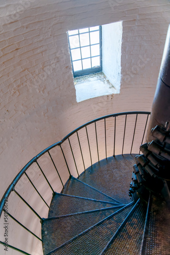 Miami, Florida- Cape Florida Lighthouse interior in Bill Baggs Cape Florida State Park. Interior of a lighthouse with white bricks and spiral stairs in perspective view heading down to the window. photo