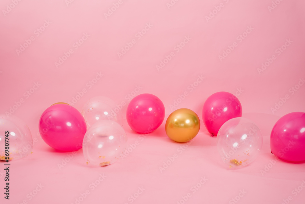 Group of multicolored transparent, pink and gold balloons lying on the floor in the house for Valentine's Day, Birthday, holiday concept